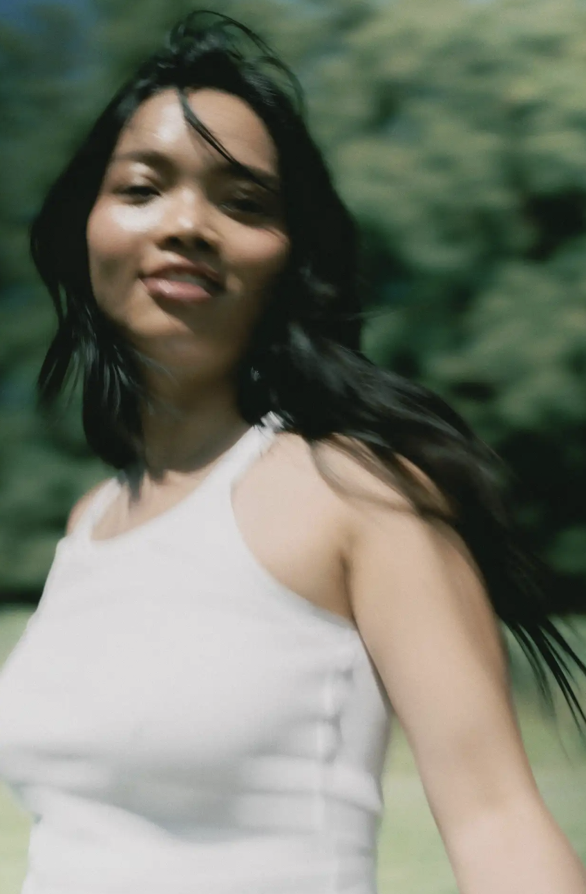A woman moving through a green landscape